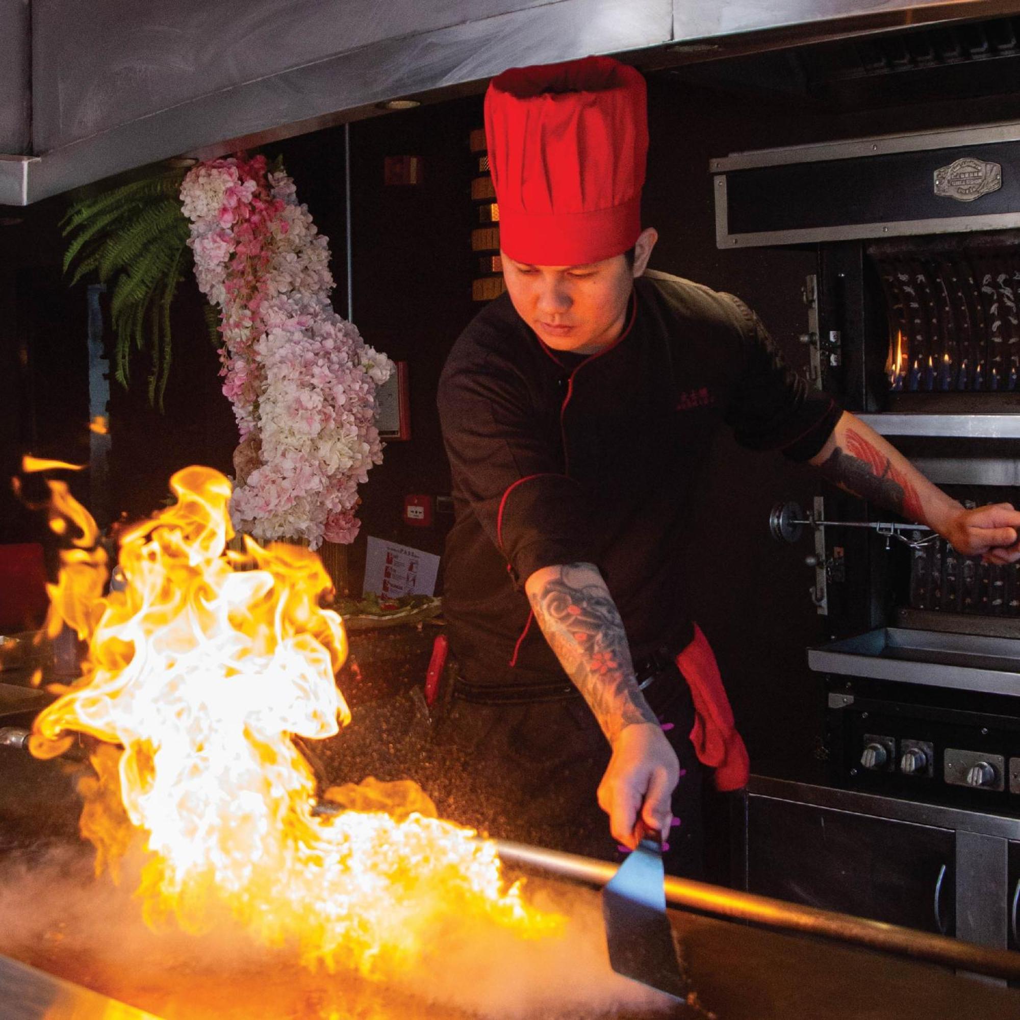 Royal Saray Resort Manama Exteriör bild A chef cooking with a flaming torch